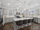 Bright kitchen featuring gray cabinets, stainless steel appliances, hardwood floors and a spacious island with seating at 124 Benford Dr, Troutman, NC 28166