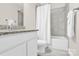 Bathroom featuring gray tiled walls, a shower-tub combo, and a shaker vanity at 12424 Bradford Park Dr, Davidson, NC 28036