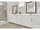 Bathroom featuring double sinks, quartz countertops, shaker cabinets, and tiled shower walls at 12424 Bradford Park Dr, Davidson, NC 28036