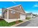 View of a two-car garage with white doors and brown siding, offering convenient parking and storage at 12424 Bradford Park Dr, Davidson, NC 28036