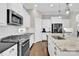 A well-equipped kitchen showcasing stainless steel appliances, sleek black countertops and island with stone countertop at 12424 Bradford Park Dr, Davidson, NC 28036