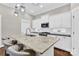 A modern kitchen features white cabinets, a stone countertop island, and stainless steel appliances at 12424 Bradford Park Dr, Davidson, NC 28036