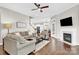 Spacious living room with a fireplace, hardwood floors, and an open layout to the kitchen at 12424 Bradford Park Dr, Davidson, NC 28036