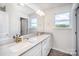 Bathroom featuring a double vanity with white cabinets, a large mirror, and a window at 1436 Yellowstone Ct, Gastonia, NC 28054