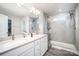 Modern bathroom featuring a double vanity, glass shower, and gray wood-look flooring at 1436 Yellowstone Ct, Gastonia, NC 28054