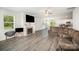 Living room with a fireplace, hardwood floors, a ceiling fan, and view into the kitchen at 1436 Yellowstone Ct, Gastonia, NC 28054