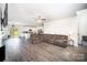 Living room with hardwood floors, a ceiling fan, view into the kitchen, and a large sectional couch at 1436 Yellowstone Ct, Gastonia, NC 28054