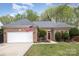 Charming brick home featuring an attached two-car garage, manicured lawn, and front entry at 147 Gabriel Dr, Mooresville, NC 28115