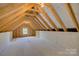 Unfinished attic space offering storage potential and a small window at 14916 Creeks Edge Dr, Charlotte, NC 28278
