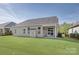Backyard view with a well-maintained lawn and covered patio, perfect for outdoor relaxation at 14916 Creeks Edge Dr, Charlotte, NC 28278