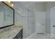 Bathroom shower enclosed in seamless glass, with neutral tiling and black hardware at 14916 Creeks Edge Dr, Charlotte, NC 28278