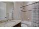 Tiled bathroom featuring a shower-tub combo and granite countertop vanity at 14916 Creeks Edge Dr, Charlotte, NC 28278