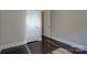 Neutral bedroom featuring dark hardwood floors, and closet door on each side of the room at 14916 Creeks Edge Dr, Charlotte, NC 28278