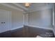 Neutral bedroom featuring dark hardwood floors, tray ceilings, and lots of natural light at 14916 Creeks Edge Dr, Charlotte, NC 28278
