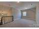 Upstairs bonus room with neutral carpet, a window, and decorative railing at 14916 Creeks Edge Dr, Charlotte, NC 28278