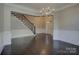 Inviting foyer featuring a grand staircase, chandelier, and beautiful dark hardwood floors at 14916 Creeks Edge Dr, Charlotte, NC 28278