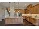Kitchen featuring an island with granite countertops, stainless steel appliances, custom cabinets, and hardwood floors at 14916 Creeks Edge Dr, Charlotte, NC 28278