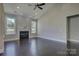 Bright living room featuring a fireplace, hardwood floors, large windows, and modern ceiling fan at 14916 Creeks Edge Dr, Charlotte, NC 28278