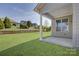 Covered patio with a view of the backyard, showing lush green space and retaining wall at 14916 Creeks Edge Dr, Charlotte, NC 28278