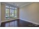 Room with dark hardwood floors, neutral walls, and natural light from large window at 14916 Creeks Edge Dr, Charlotte, NC 28278