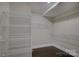 Walk-in closet featuring custom shelving and dark hardwood floors at 14916 Creeks Edge Dr, Charlotte, NC 28278