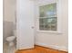 Bathroom featuring toilet with window, hardwood floors and modern fixtures at 1519 Briarfield Dr, Charlotte, NC 28205