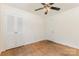 Bedroom with hardwood floors, a ceiling fan, and double-door closet at 1519 Briarfield Dr, Charlotte, NC 28205