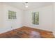 This bedroom features hardwood flooring and two windows providing lots of natural light at 1519 Briarfield Dr, Charlotte, NC 28205