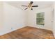 A bedroom featuring hardwood floors, ceiling fan and a window with a view of the outdoors at 1519 Briarfield Dr, Charlotte, NC 28205