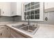 A stainless steel sink with grey tile backsplash, and a window that provides natural light at 1519 Briarfield Dr, Charlotte, NC 28205