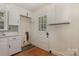 Laundry area with white cabinets, utility sink, and door to the exterior at 1519 Briarfield Dr, Charlotte, NC 28205