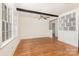This spacious living room boasts hardwood floors, beamed ceilings, large windows, and a ceiling fan at 1519 Briarfield Dr, Charlotte, NC 28205