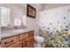 Well-lit bathroom featuring a vanity with a granite countertop and a shower with a decorative curtain at 15212 Keyes Meadow Way, Huntersville, NC 28078