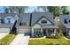 Charming home with a stone-accented facade, manicured lawn, and an attached two-car garage at 15212 Keyes Meadow Way, Huntersville, NC 28078