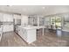 Bright, open kitchen features white cabinets, large island, stainless steel appliances and breakfast nook at 15212 Keyes Meadow Way, Huntersville, NC 28078