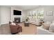 Cozy living room features a fireplace, hardwood floors, and lots of natural light from the many windows at 15212 Keyes Meadow Way, Huntersville, NC 28078