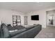 Comfortable living room with a large gray sofa, media setup, and stylish shelving for organized living at 15212 Keyes Meadow Way, Huntersville, NC 28078