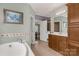 Comfortable bathroom with tub, vanity, and neutral colors, and view into connecting hall at 1853 Beach Ln, Heath Springs, SC 29058