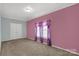 Bedroom with light pink walls and neutral carpeting with window and closet at 1853 Beach Ln, Heath Springs, SC 29058