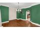 An empty dining room features green walls, crown molding and hardwood floors at 1853 Beach Ln, Heath Springs, SC 29058
