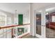 Upstairs hallway with railing and view into living room through glass paneled doors at 1853 Beach Ln, Heath Springs, SC 29058