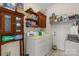A laundry room with a washer and dryer, shelves, and wooden cabinets at 1853 Beach Ln, Heath Springs, SC 29058
