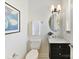 Bright bathroom featuring a white toilet, oval mirror, and marble countertop on a black vanity at 1904 Lela Ave, Charlotte, NC 28208