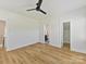 Light-filled bedroom with hardwood floors featuring a ceiling fan, walk-in closet, and en-suite bathroom at 1904 Lela Ave, Charlotte, NC 28208