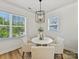 Breakfast nook featuring modern light fixture, white table and chairs, wood floors, and natural light at 1904 Lela Ave, Charlotte, NC 28208
