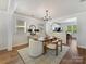 Bright dining room boasts wood floors, modern light fixture, and an open layout into the kitchen at 1904 Lela Ave, Charlotte, NC 28208