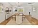 Elegant dining room featuring wood floors, modern light fixture, and open layout into the kitchen at 1904 Lela Ave, Charlotte, NC 28208