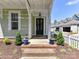 Welcoming front porch with a stylish black door, decorative plants, and brick steps at 1904 Lela Ave, Charlotte, NC 28208
