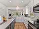 Modern kitchen with white cabinetry, gray subway tile, stainless steel appliances, and open layout at 1904 Lela Ave, Charlotte, NC 28208