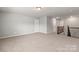 Spacious bonus room with a neutral color palette, carpet and staircase with dark wooden banister at 2031 Killian Creek Dr, Denver, NC 28037